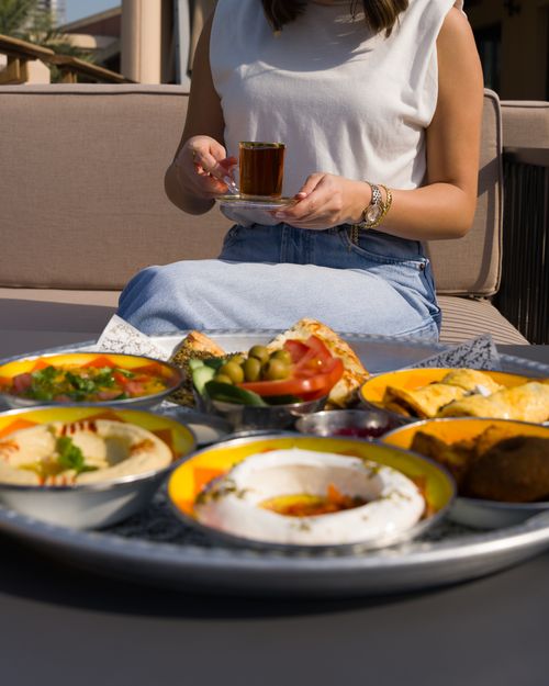 Free Person enjoying Middle Eastern brunch outdoors with tea. Stock Photo