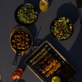Grilled skewers served in cast pans — photo by Ali Dashti on Pexels