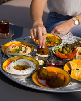 Enjoy a vibrant Middle Eastern mezze platter with falafel, hummus, and fresh vegetables.