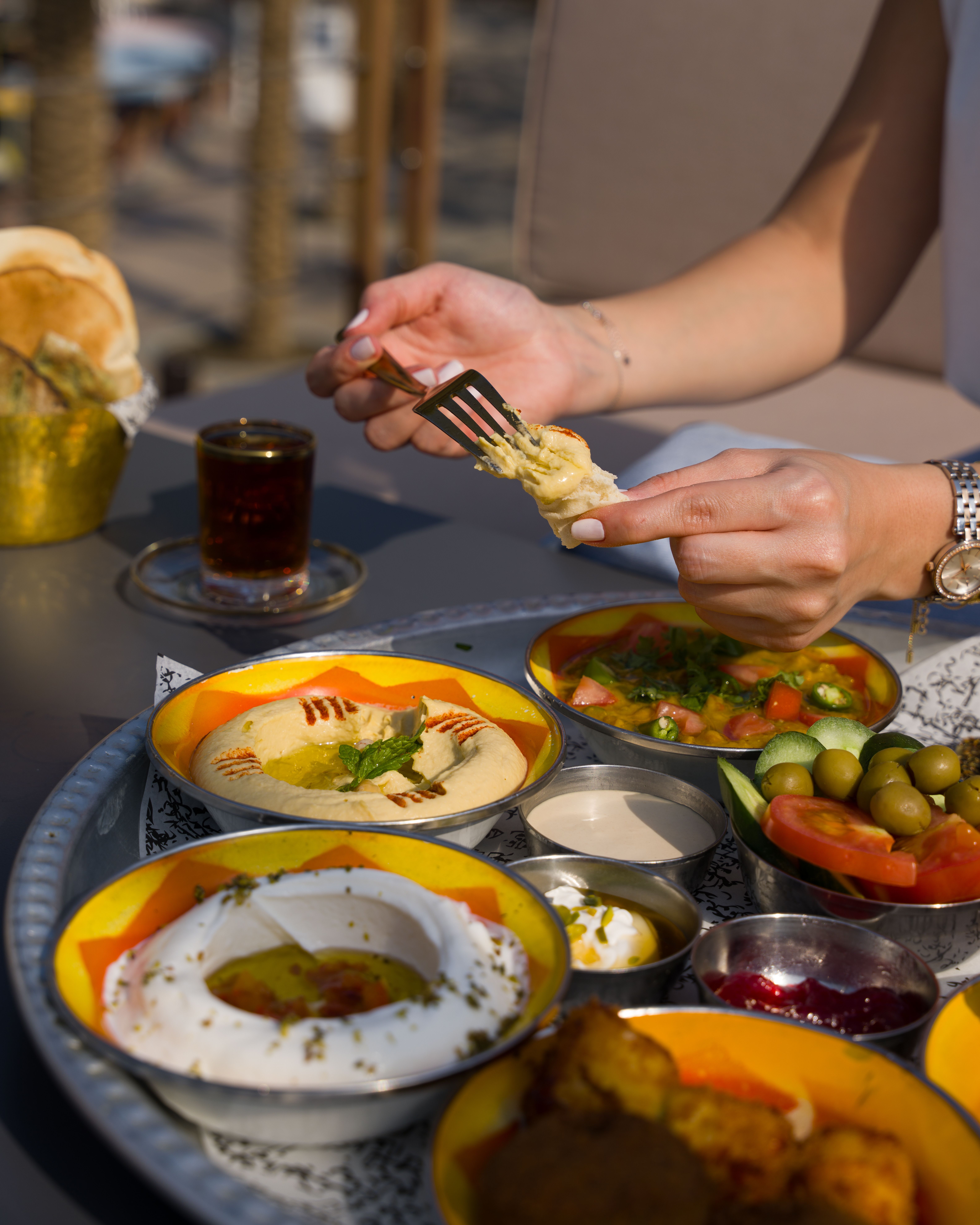 Ücretsiz Humus ve zeytinin açık havada servis edildiği, sıcak bir atmosfer yaratan canlı bir Ortadoğu yemeği. Stok Fotoğraflar