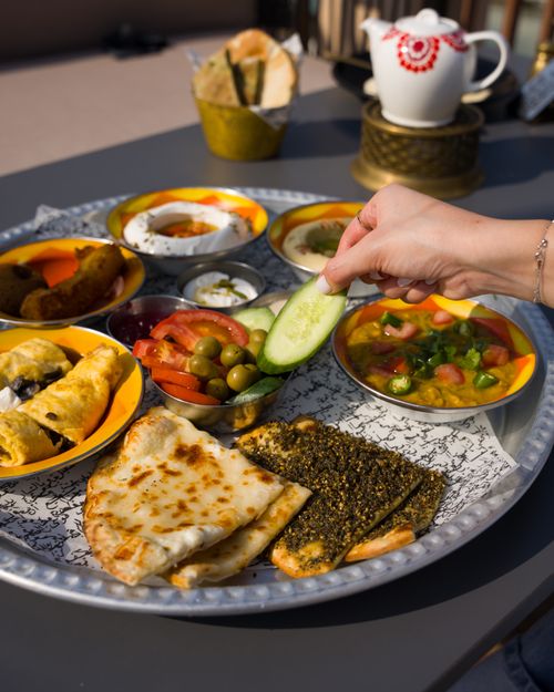 Free Colorful Middle Eastern mezze platter with traditional tea setup, perfect for cultural dining experiences. Stock Photo
