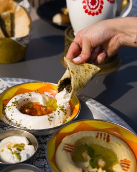 Middle Eastern flatbread dipped in creamy mezze with yogurt and hummus.