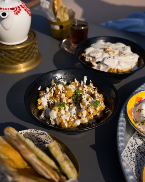Free Middle Eastern dishes with tea in an outdoor setting. Perfect for food lovers. Stock Photo
