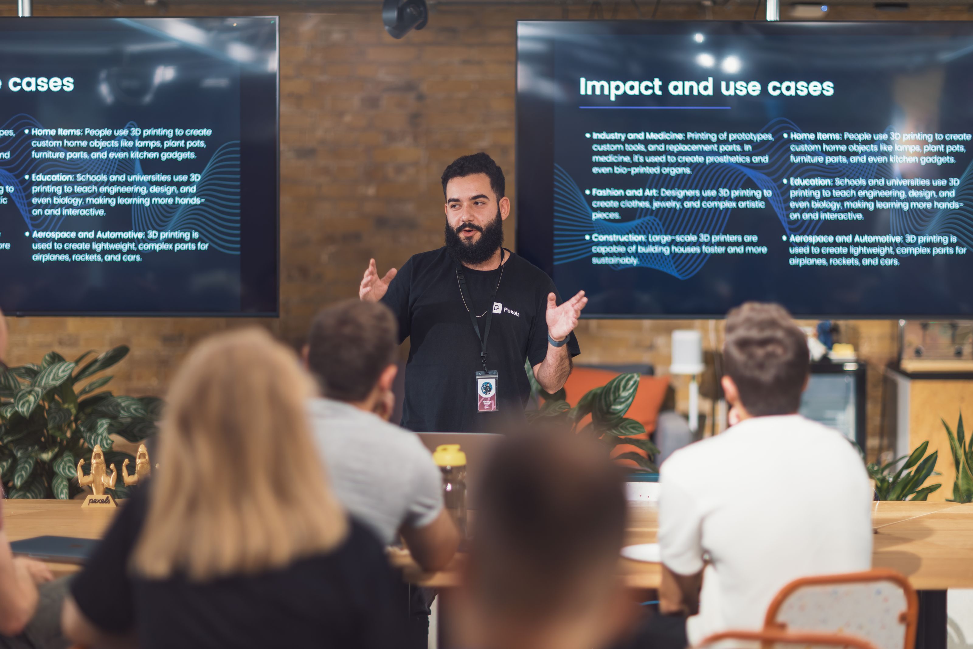 Professional speaker discusses 3D printing applications with attentive audience in tech seminar.