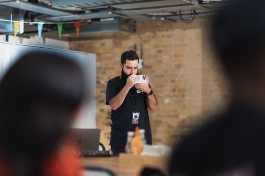A male photographer taking pictures at an indoor office event, focusing on a creative atmosphere.
