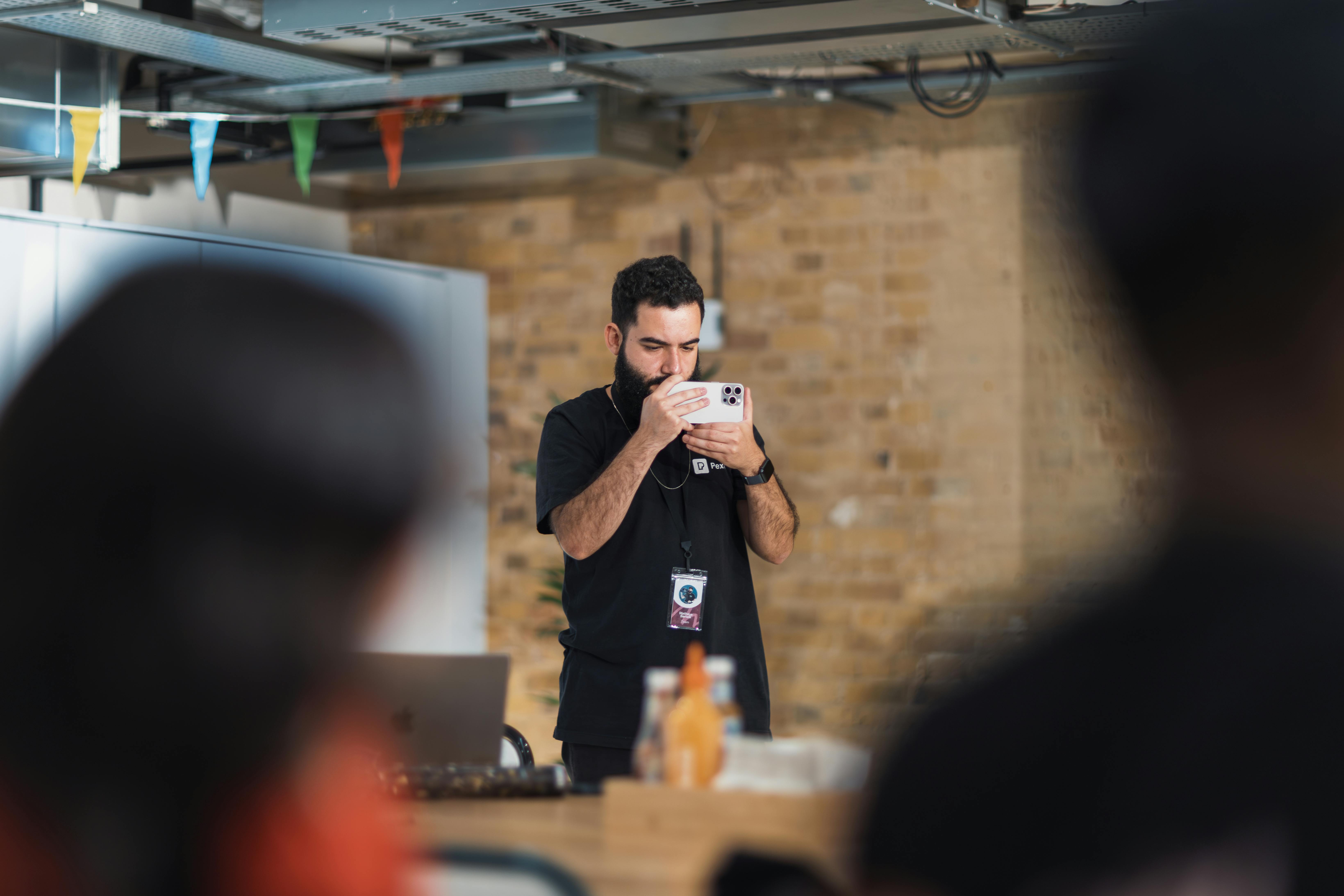 Gratuit Un fotograf bărbat care face fotografii la un eveniment de birou interior, concentrându-se pe o atmosferă creativă. Fotografie de stoc