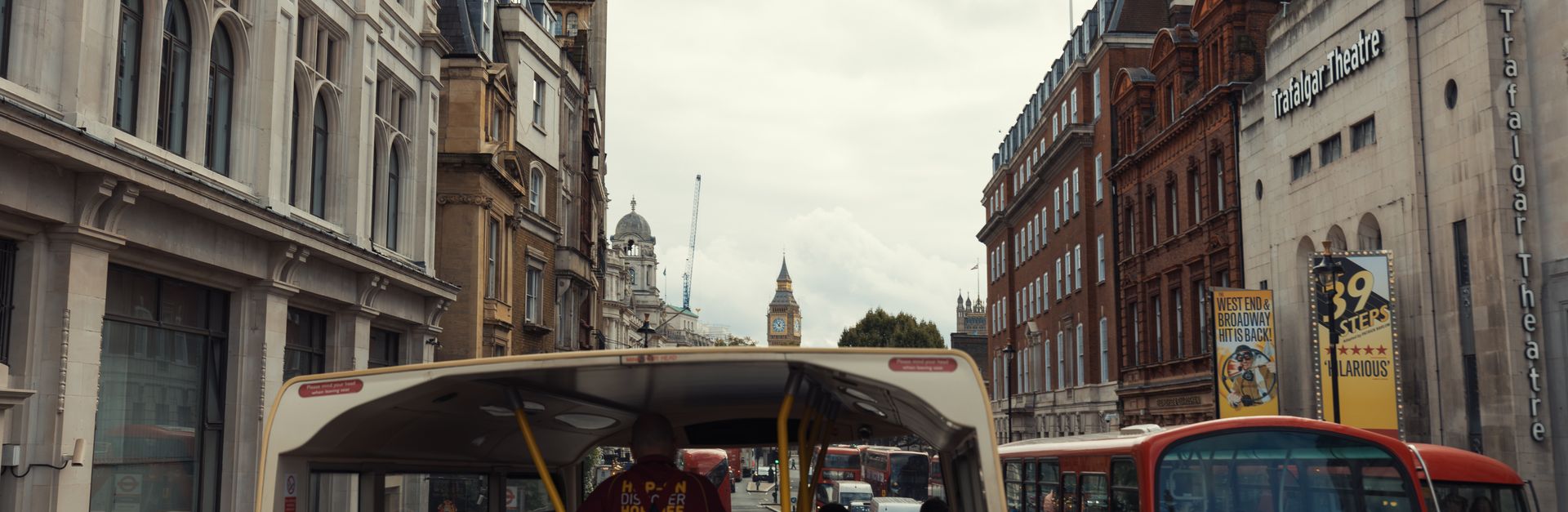 View from a double-decker bus touring central London with Big Ben in the distance.