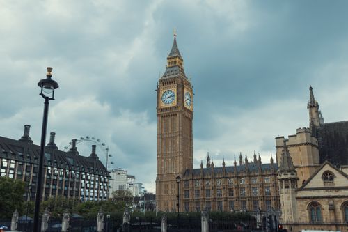 Free Iconic view of Big Ben and the London Eye under a cloudy sky in London. Stock Photo