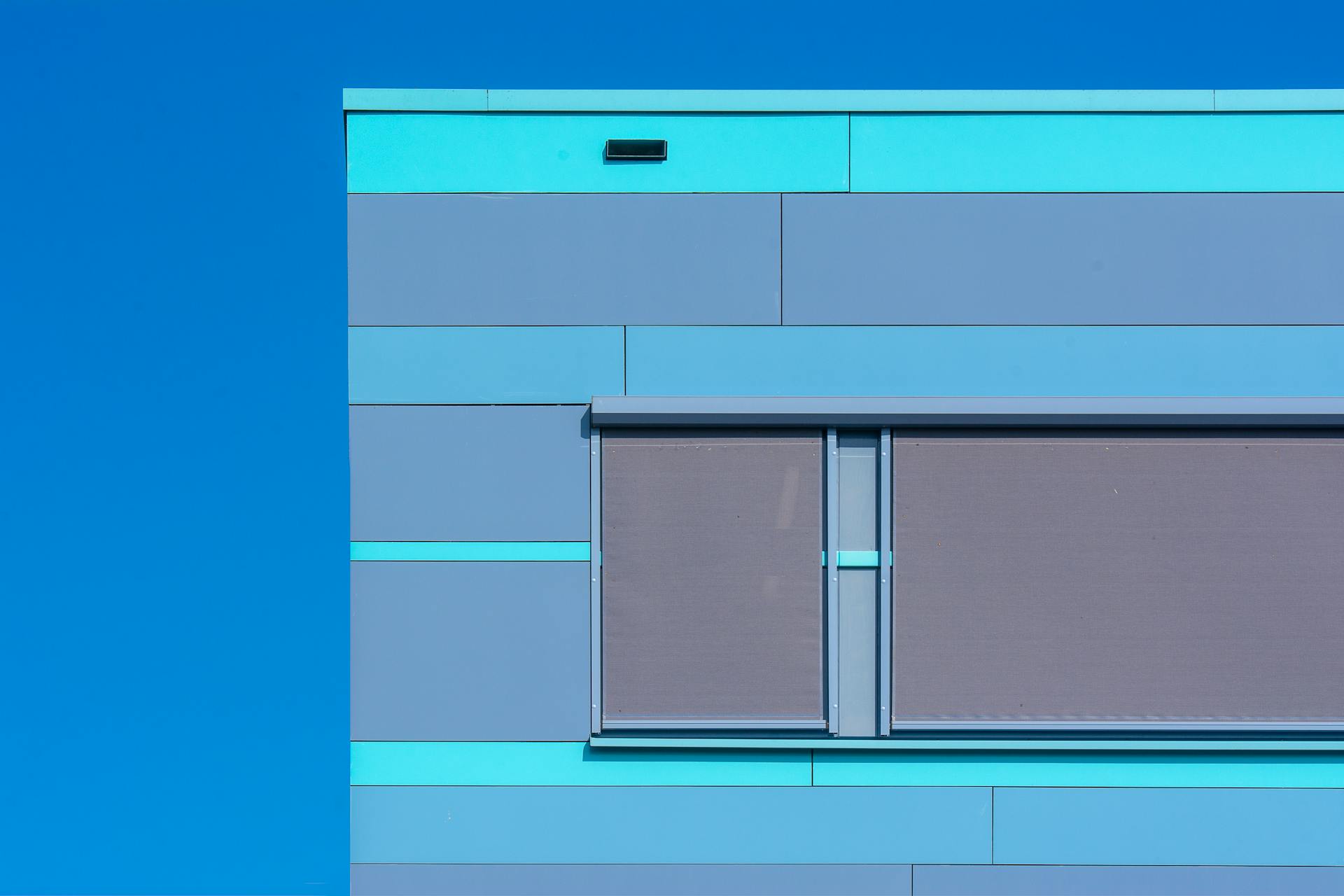 Minimalist photo of a modern blue building facade with geometric design.