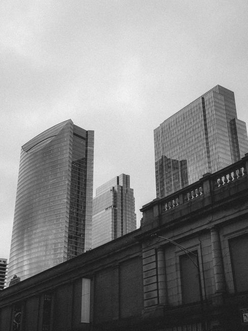 Black and white photo of modern skyscrapers towering against a moody sky.