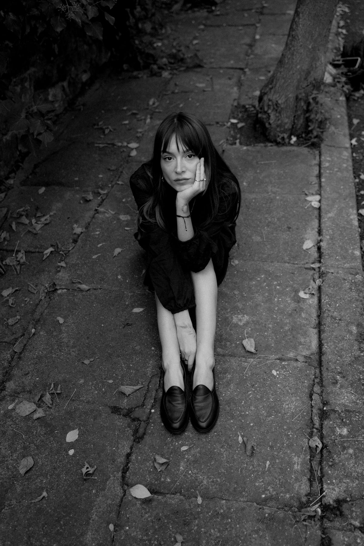 A pensive woman sitting outdoors in flat shoes — the reinvented flat