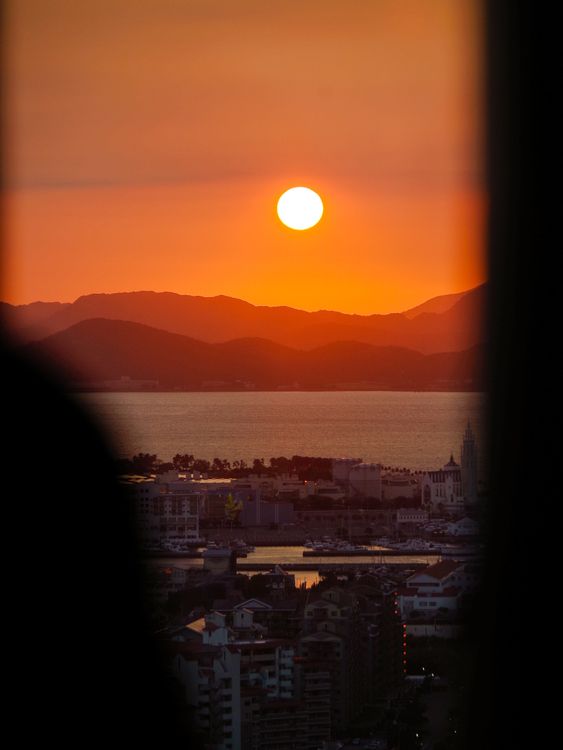 Sunset over Fukuoka cityscape with the sea and hills behind