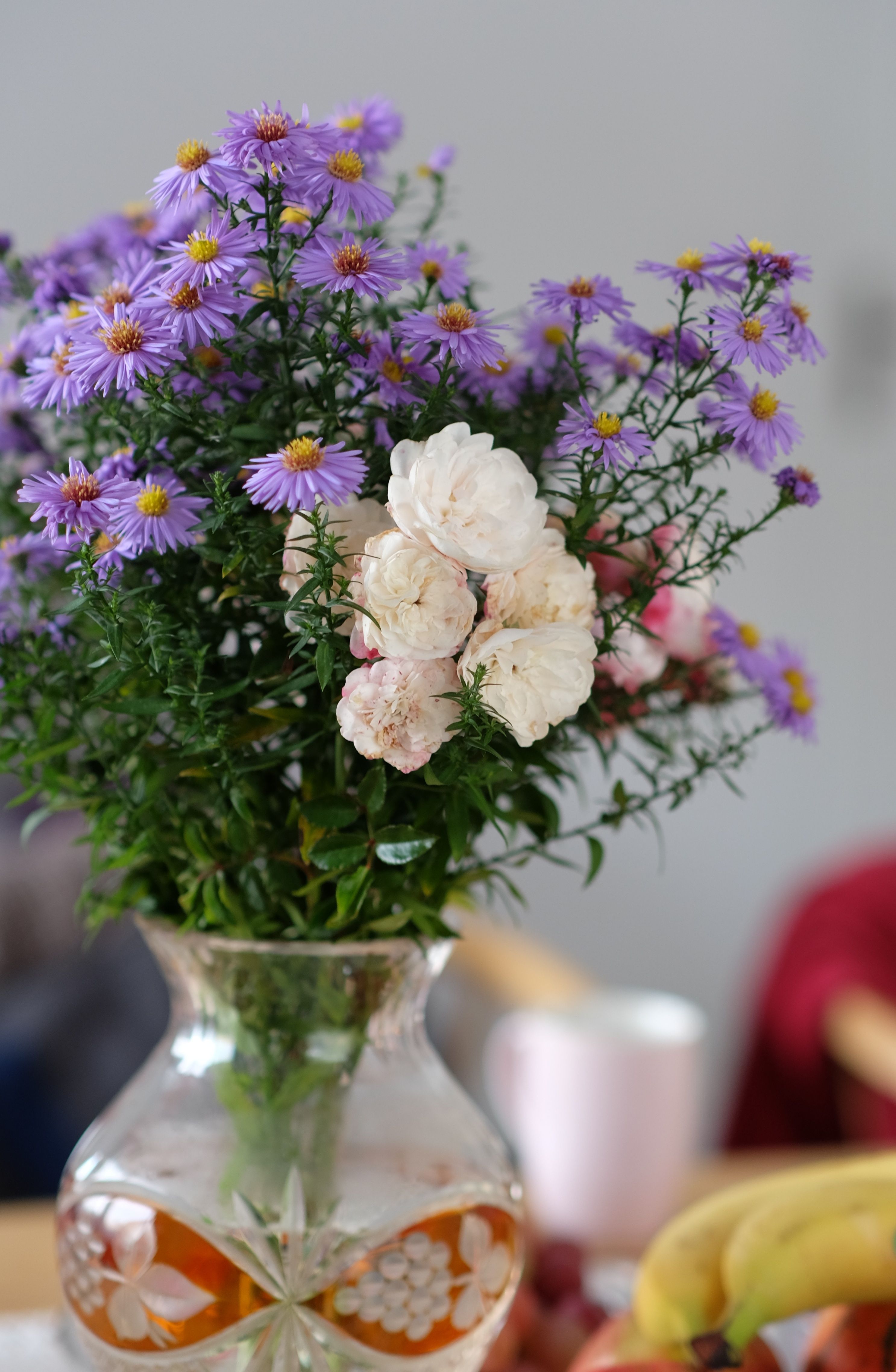 [ColoSach]-colorful-bouquet-of-purple-asters-and-white-flowers-in-a-decorative-glass-vase-on-a-table.
