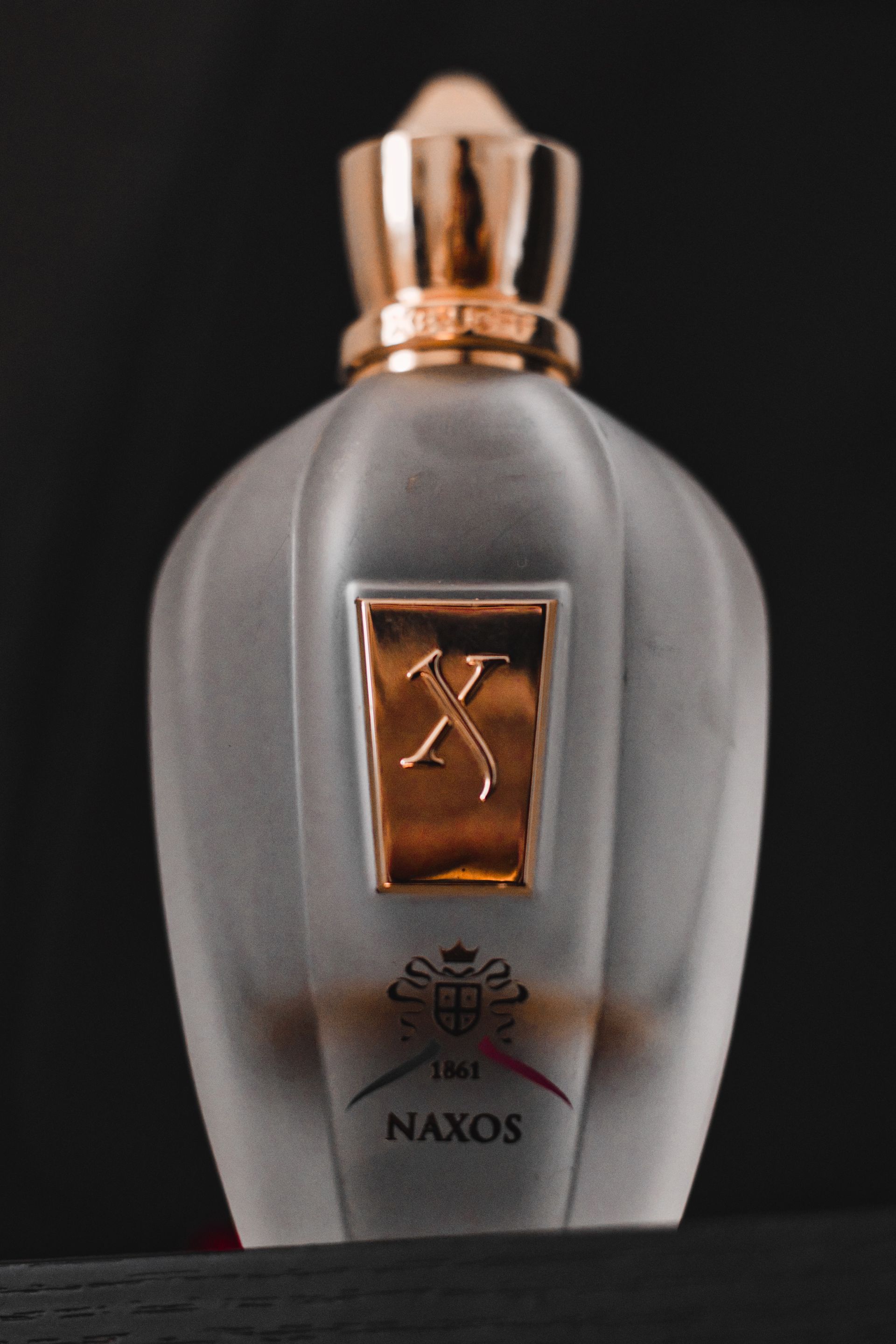 Elegant Naxos fragrance bottle with gold accents - Photo by Manish Jain on Pexels