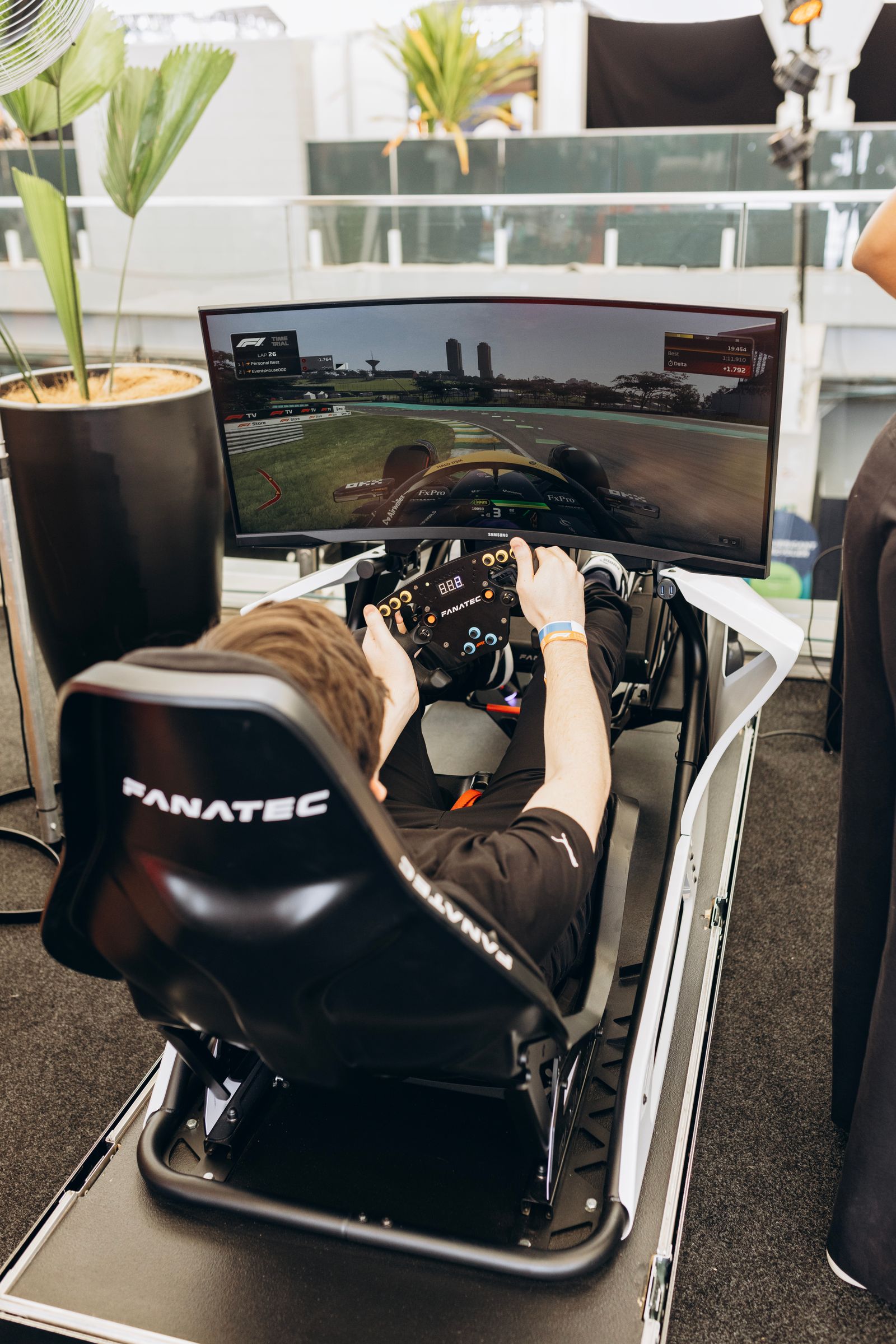 Player using an immersive racing simulator with a panoramic gaming display