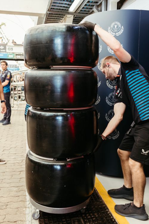 Formula One Pit Crew Stacking Racing Tires · Free Stock Photo