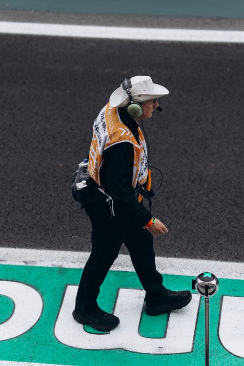 Track Racing Officials Race Official Walking on Track in Headgear · Free Stock Photo