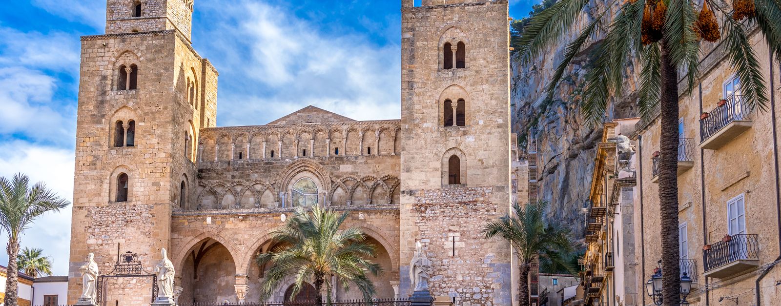 Stunning view of the historic Cefalù Cathedral in Sicily, Italy, under a bright blue sky.