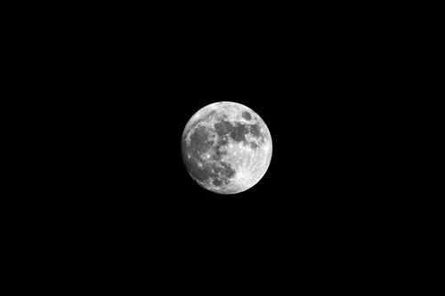 Free Capture of the full moon set against a pitch black sky, highlighting lunar details. Stock Photo