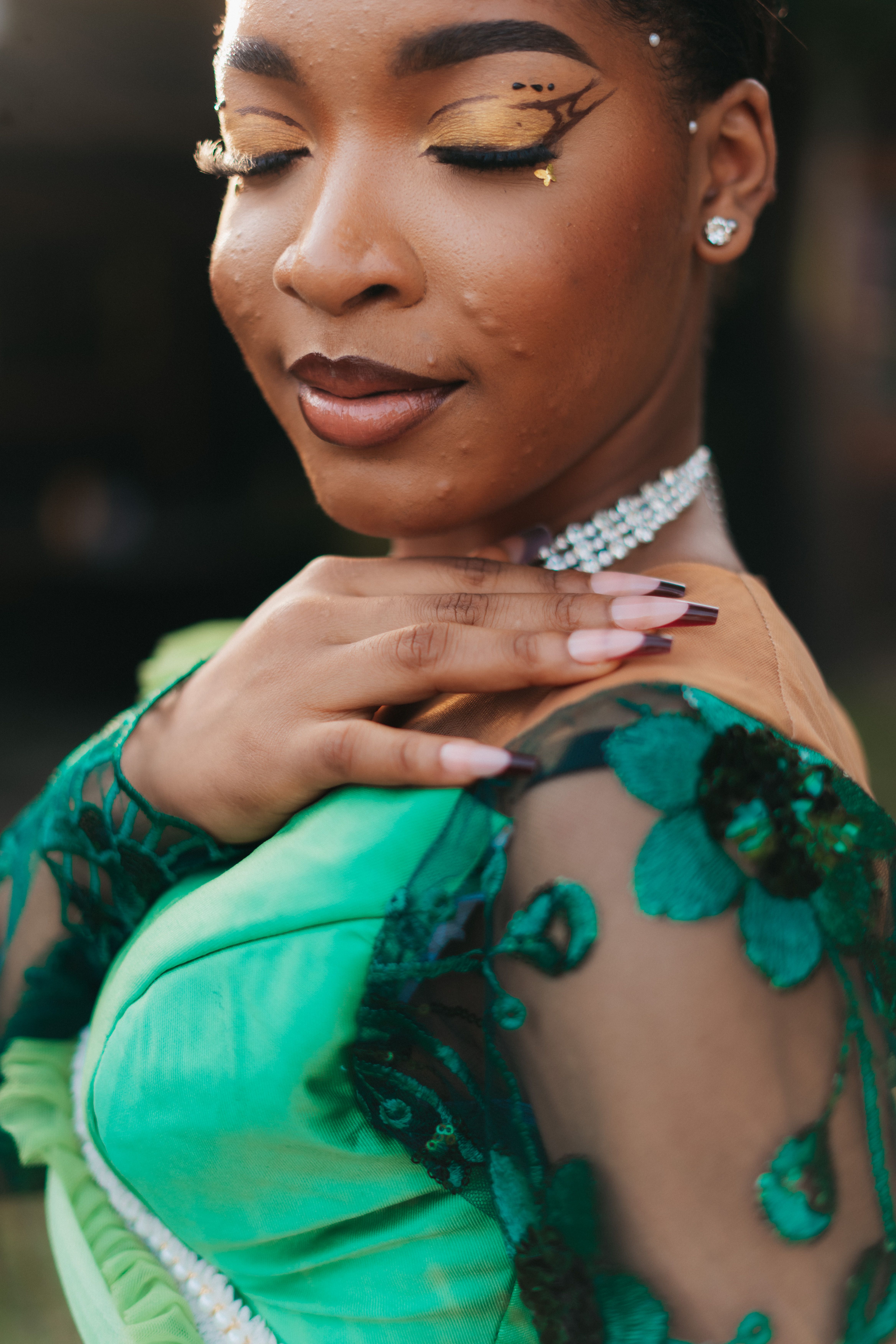 Close-up portrait of a woman in colorful attire with artistic makeup, embodying elegance and style.