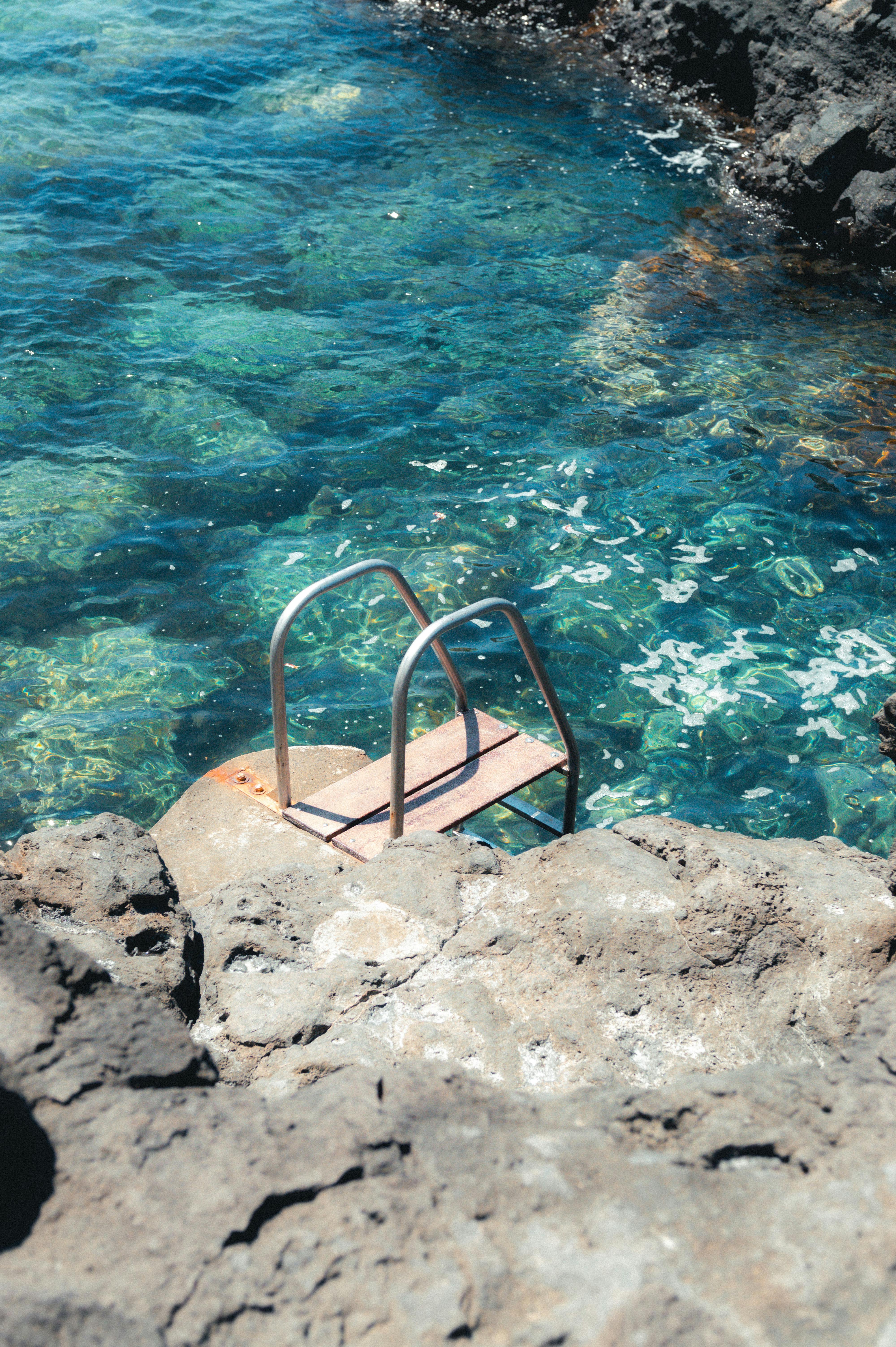 Scenic view of a clear blue lagoon with rocky surroundings in Lanzarote, Spain. Perfect for summer escape.