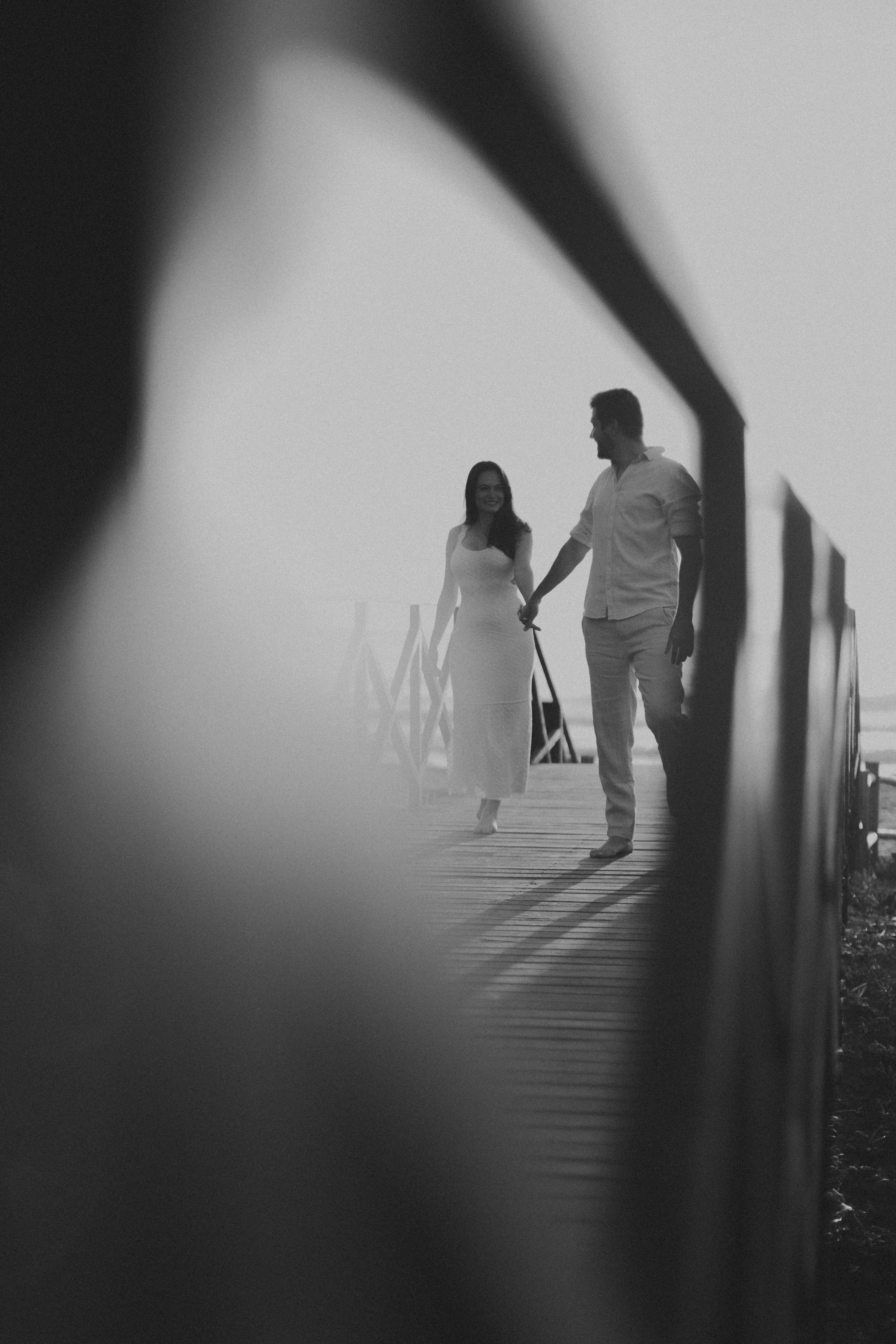 무료 고요한 풍경 속 나무다리 위에서 손을 잡고 걷는 커플. 스톡 사진