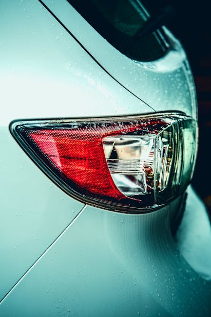 Detailed shot of a car's taillight with raindrops in Huddersfield, UK.