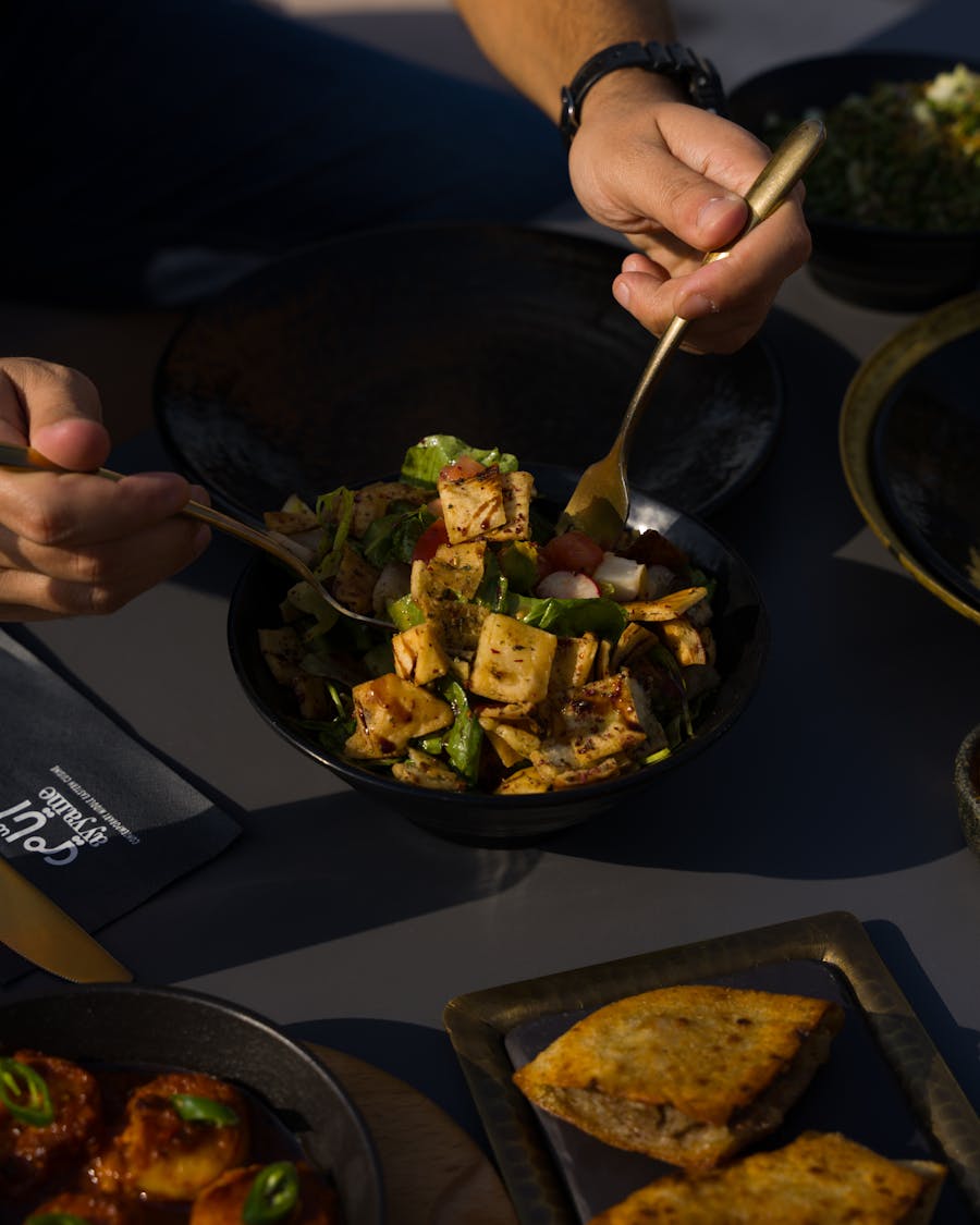 Main dégustant une salade vegan colorée en extérieur