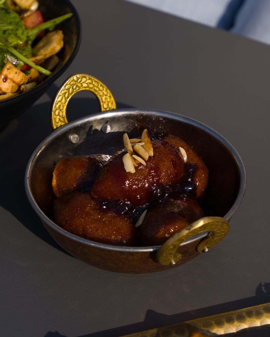 Gulab jamun in a decorative bowl with almonds