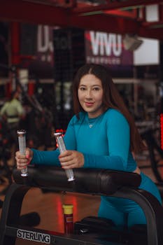 Young woman working out on fitness equipment in a modern gym environment.