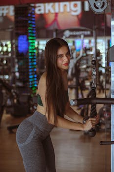 A young woman working out using gym equipment, focusing on fitness and health.