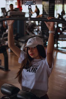 A young woman performs a workout in a gym, emphasizing fitness and health.