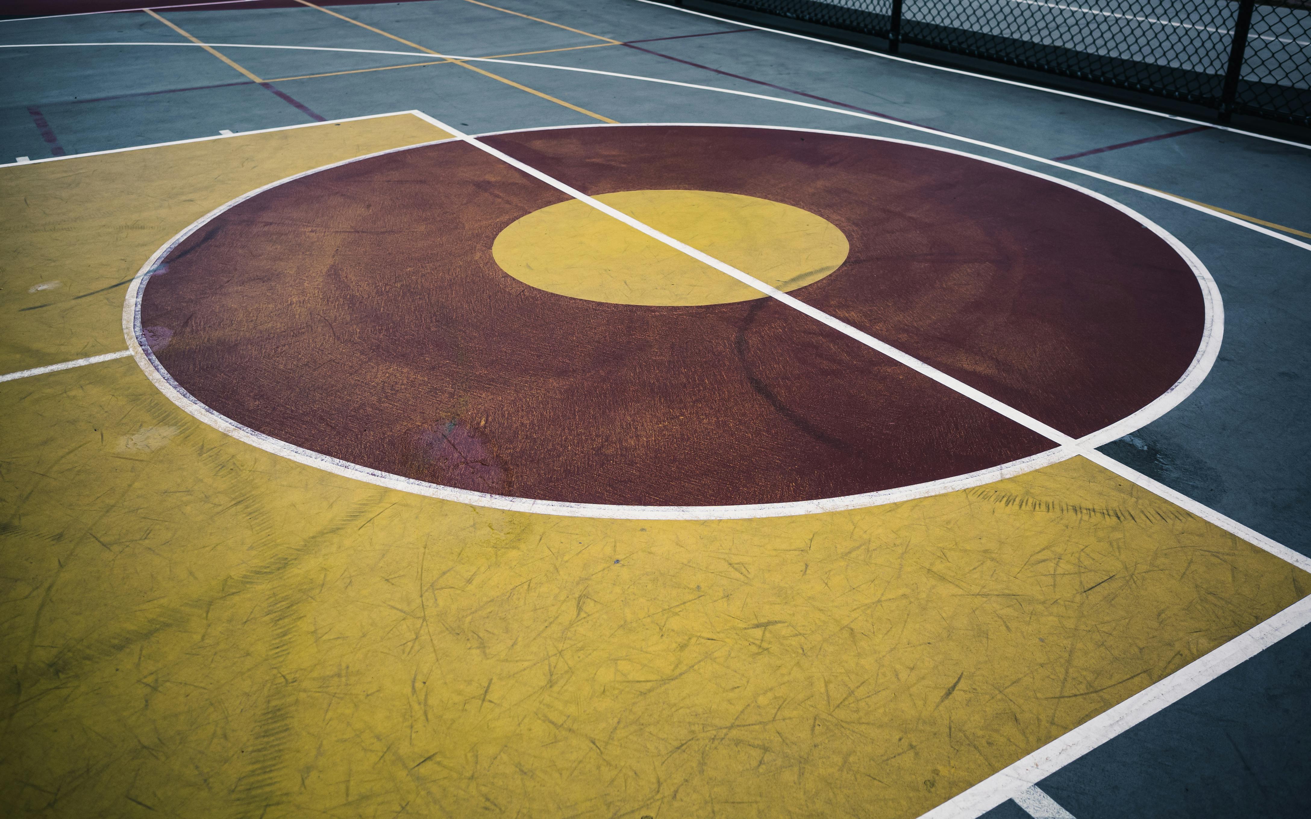 gratis Levendige cirkels op een basketbalveld in de buitenlucht met opvallende markeringen. Stockfoto