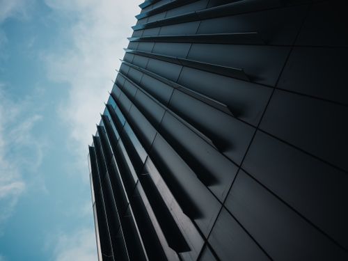 Free Dynamic architectural facade captured from below with a clear blue sky. Stock Photo