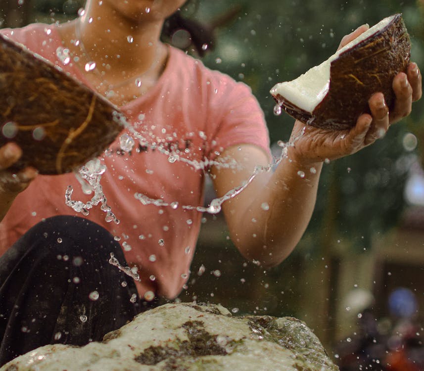 Free Photo Of Woman Cracking Coconut Shells Stock Photo