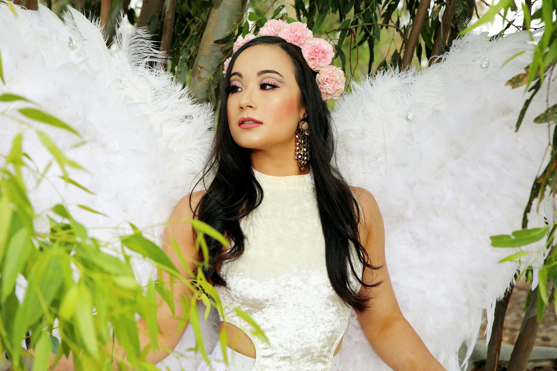 Woman with angel wings and floral crown, serene and enchanting.