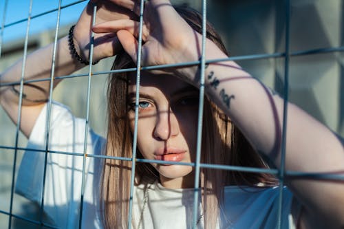 Photo Of Woman Leaning On Screen Fence