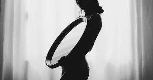鏡を運ぶ女性のグレースケール写真