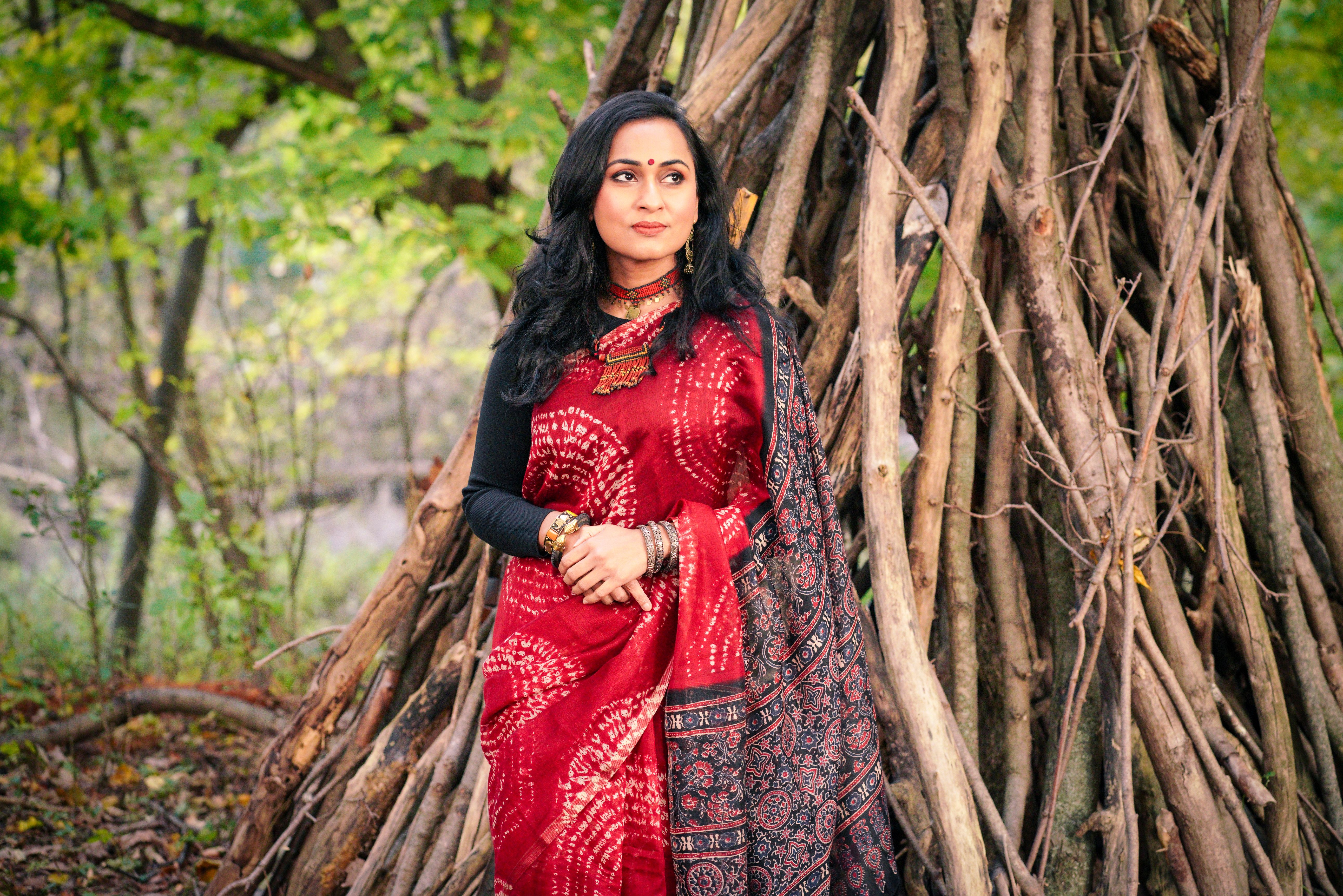 Elegant Woman in Red Sari in a Forest Setting · Free Stock Photo