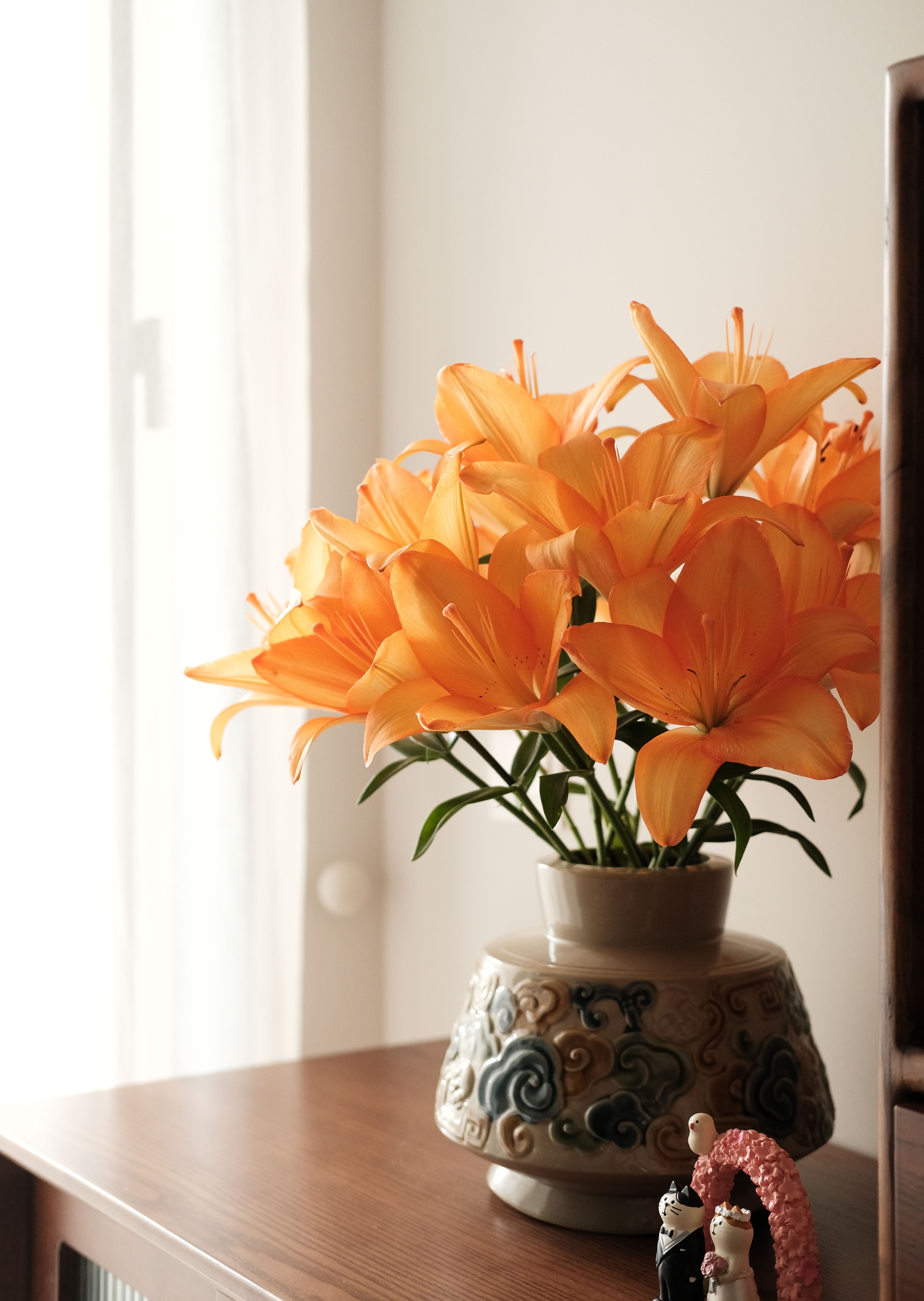 Bold orange lily bouquet in a tall glass vase