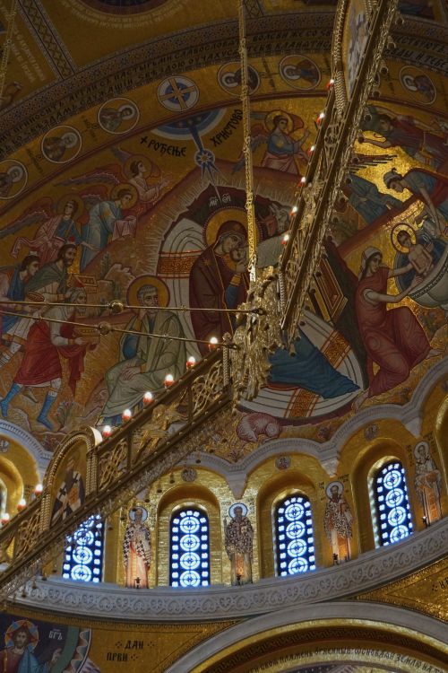 Free Intricate religious fresco depicting saints inside a church dome with golden hues. Stock Photo