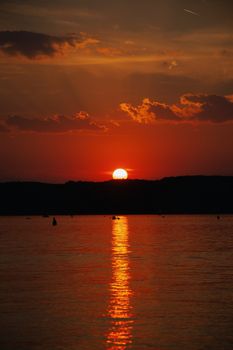 Captivating sunset view over Lake Balaton with vivid orange hues reflecting on water.