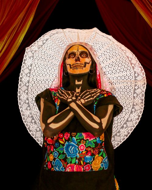 Free A woman with colorful face paint and floral dress celebrating the Day of the Dead festival. Stock Photo