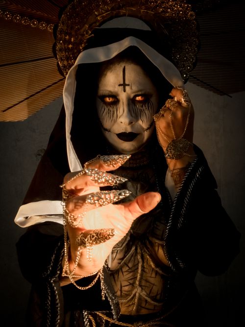 Free A haunting image of a nun in horror makeup featuring dramatic lighting and Halloween elements. Stock Photo