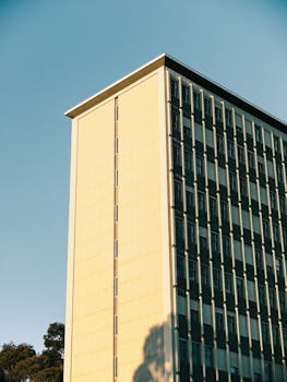 Contemporary high-rise building with clear blue sky, showcasing modern architecture.