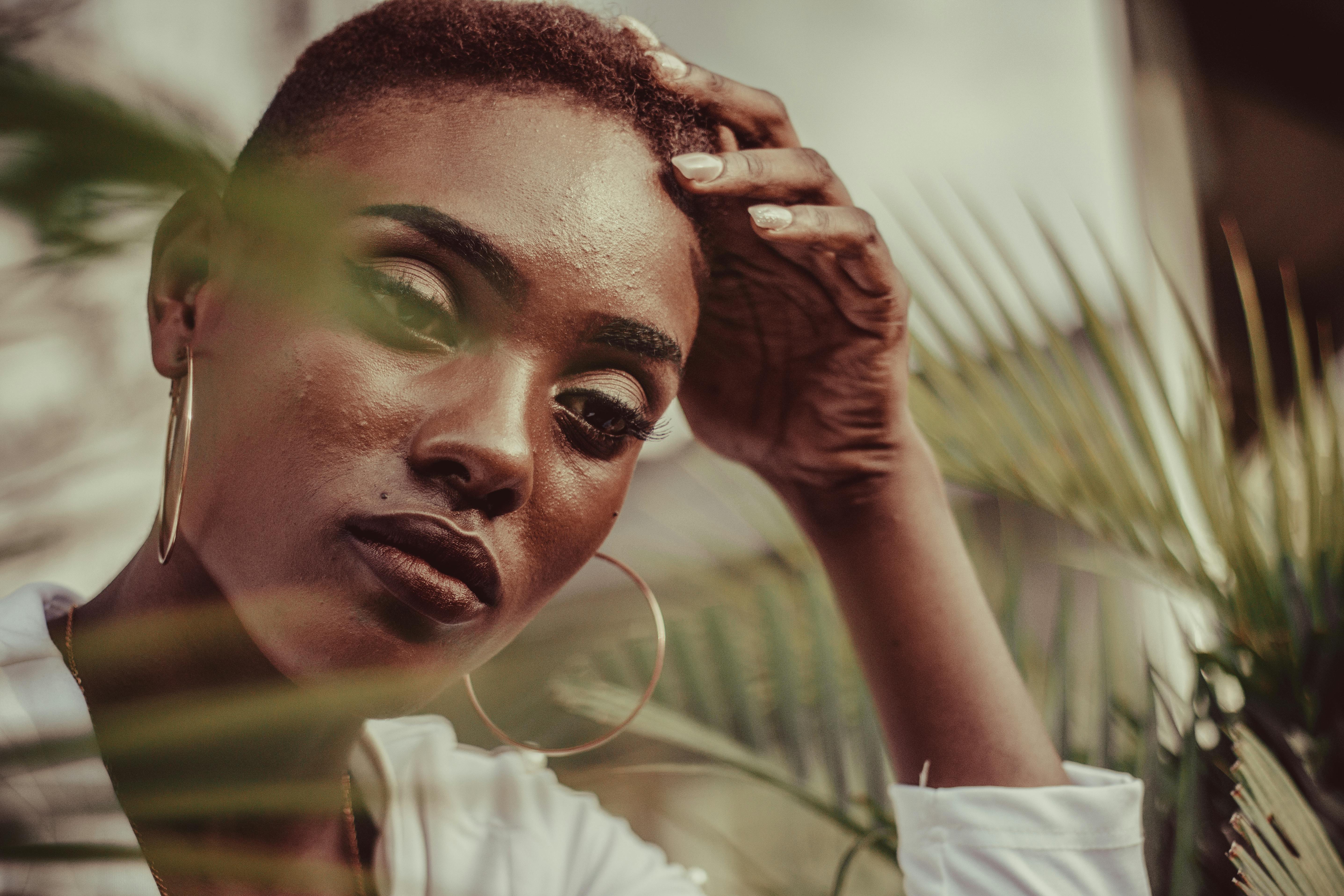 一位女性正倚靠着，表情深思，她的特写肖像被自然元素环绕