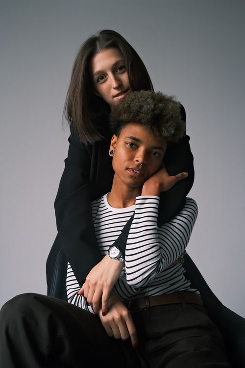 Free A heartfelt portrait of a diverse couple embracing inside a studio setting. Stock Photo