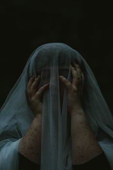 Mysterious woman covered with a veil in a dark, magical forest setting, evoking a sense of enchantment and mystery.