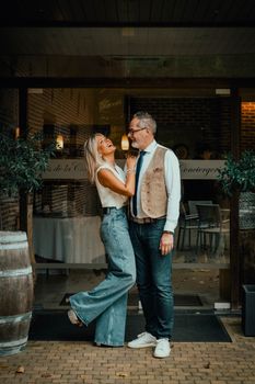 Couple sharing a joyful moment outside a restaurant in Brunehaut, Belgium.