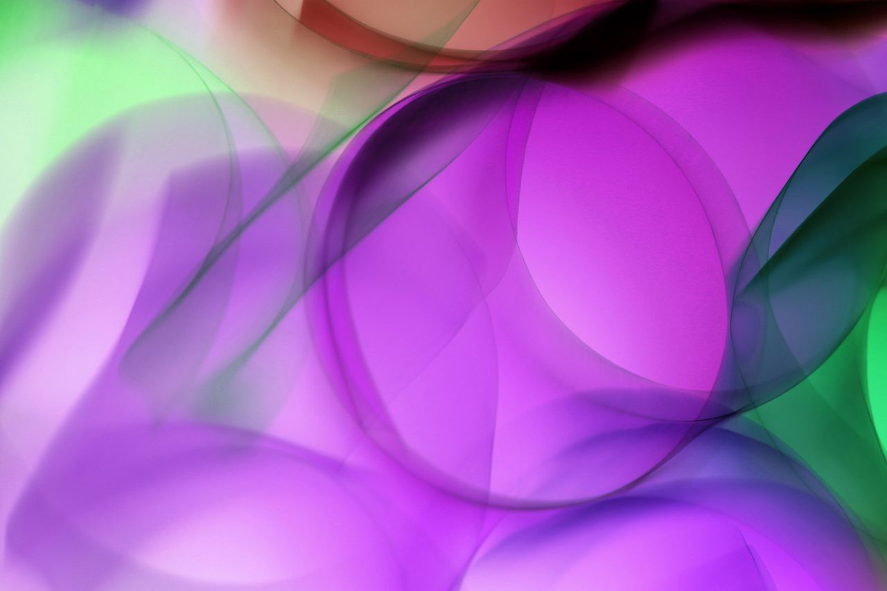 vibrant abstract design of overlapping purple and green waves and circ